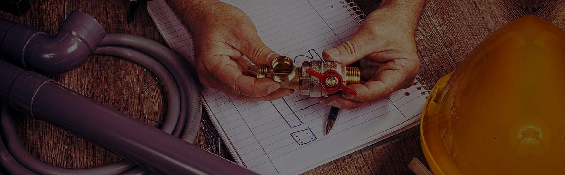 Plumbers-Hands-Holding-A-Brass-Valve-Fitting-Plumbing-Pipes